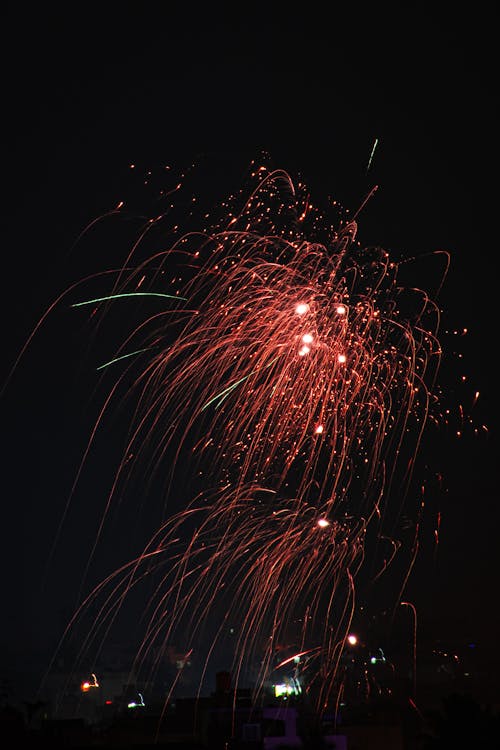 Red Fireworks in the Night Sky Over the City