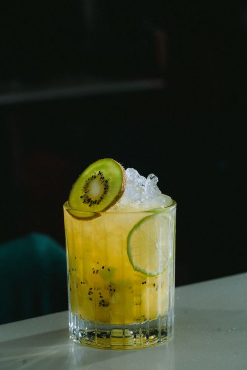 Free Chilled tropical kiwi citrus drink garnished with fresh fruit slices and ice cubes. Stock Photo