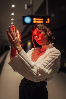 Artistic portrait of a woman in a dimly lit subway station, showcasing a warm, dramatic atmosphere.