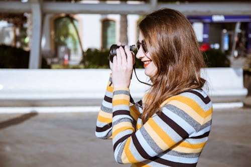 Free Smiling Woman Taking S Hot With Camera Beside White Building Stock Photo