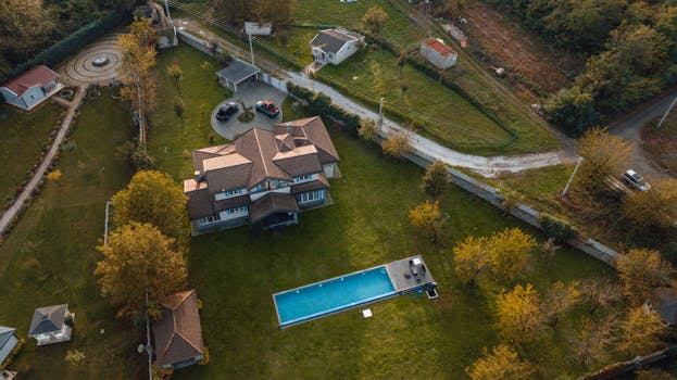 An aerial photograph showcases a beautiful villa with a pool amidst autumnal surroundings in İzmit, Türkiye.