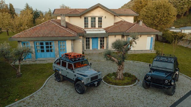 Aerial view of a luxury villa with two SUVs parked on a circular driveway in İzmit, Türkiye.