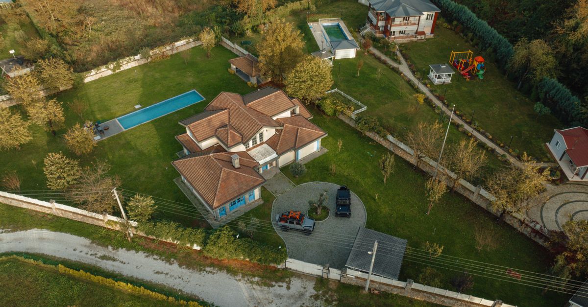 Aerial shot of suburban houses with pools in İzmit, Kocaeli, Türkiye, showcasing spacious lawns.