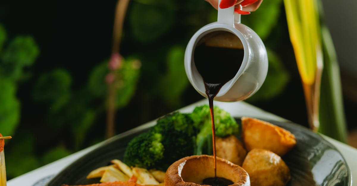 Close-up of Woman Pouring Sauce on a Dish · Free Stock Photo
