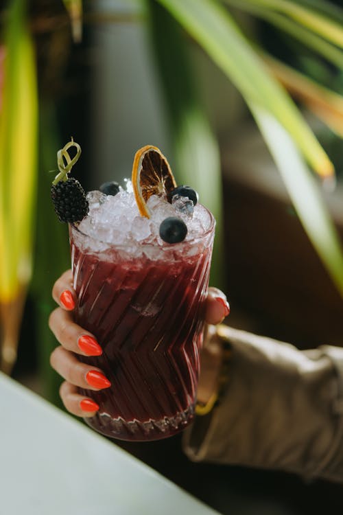 Woman Hand Holding Glass with Fruit Cocktail