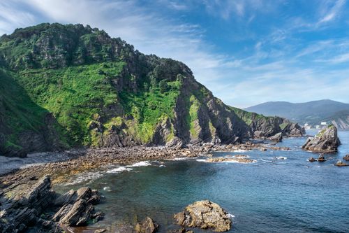 Free Breathtaking aerial view of green cliffs and rocky shorelines by a serene sea. Stock Photo