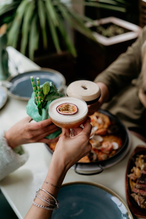 Free People Clinking Glasses over the Table with Food  Stock Photo