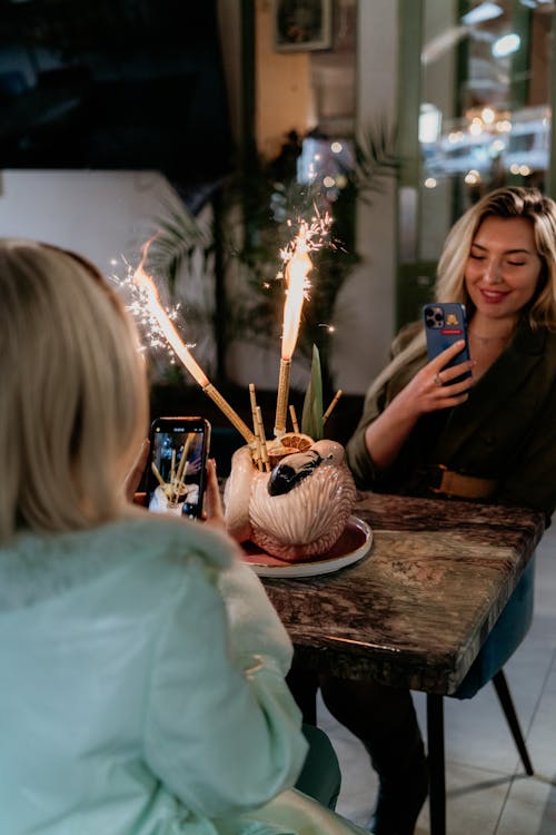 Women Filming a Cake on the Table in a Restaurant 