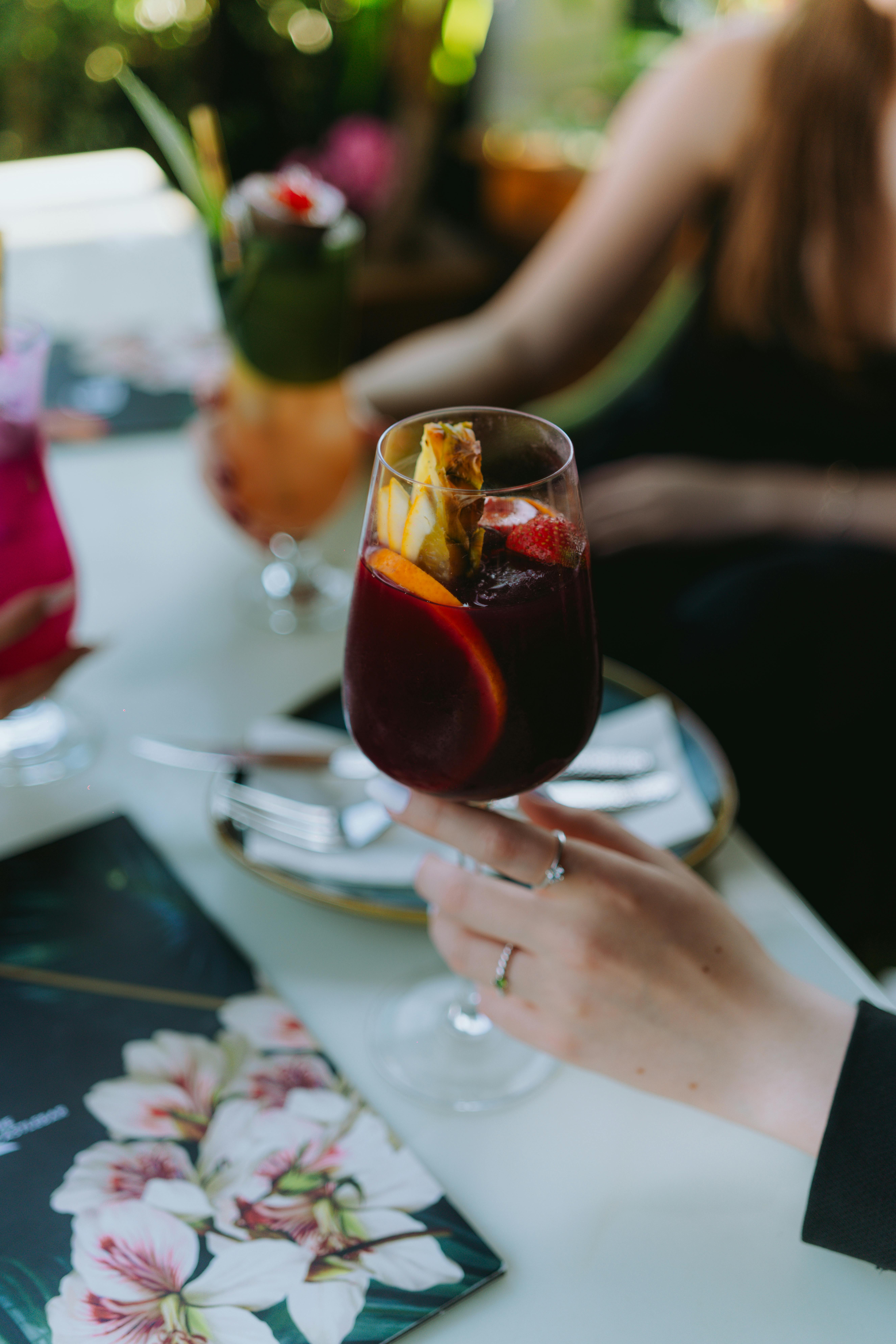Close-up view of a vibrant sangria with fruits in a stylish restaurant setting. Perfect for lifestyle and dining visuals.