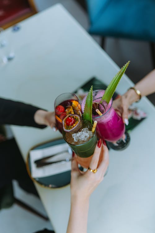 Women Hands Holding Fruit Cocktails