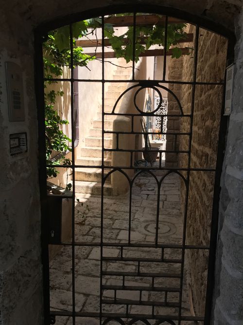Free View through an iron gate to a narrow passage in Tel Aviv, showcasing historic stone architecture. Stock Photo