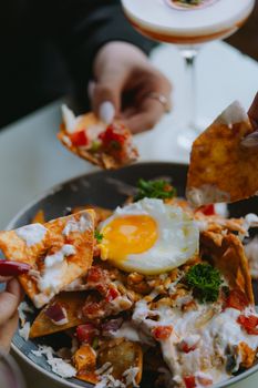 Appetizing plate of nachos topped with a sunny side up egg, perfect for brunch or a casual meal.