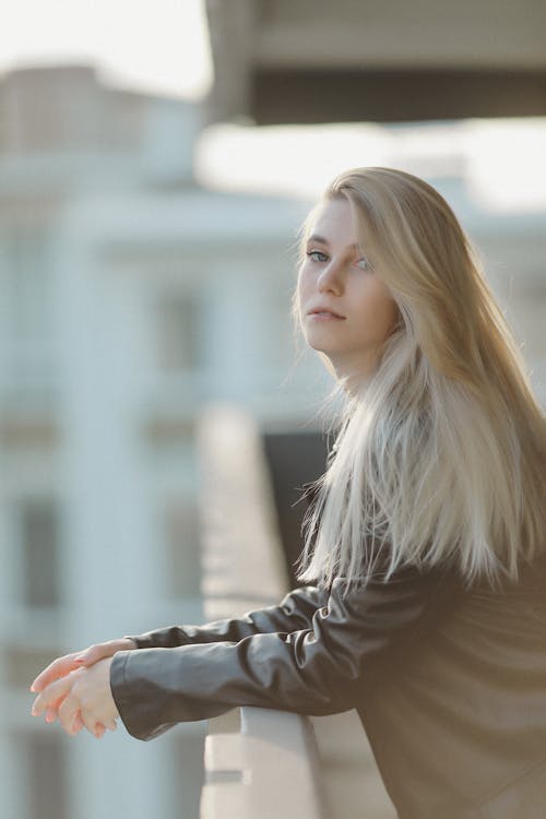 Blonde Woman Wearing Leather Jacket on a Balcony