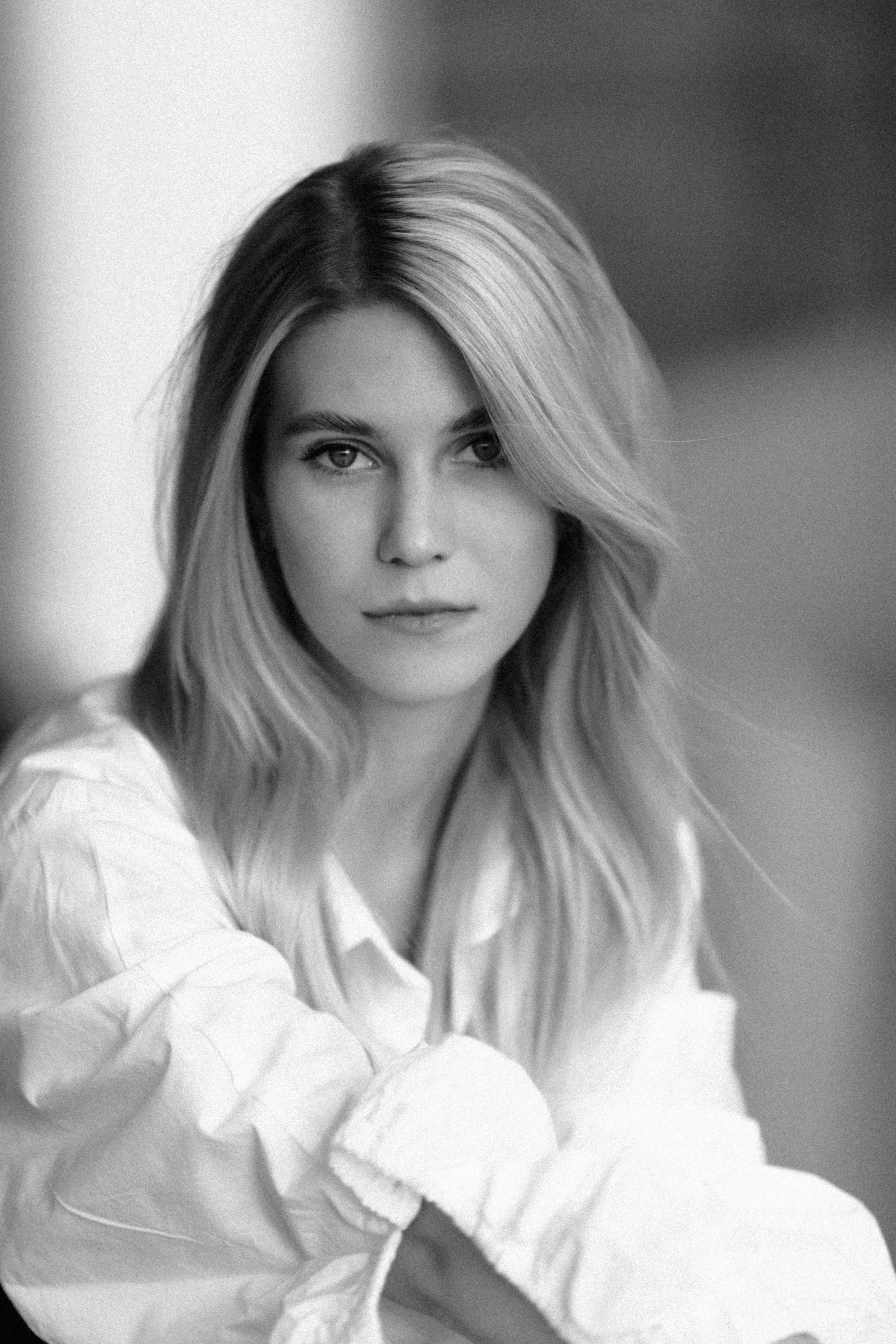 Timeless black and white portrait of a woman in a crisp shirt, exuding elegance.