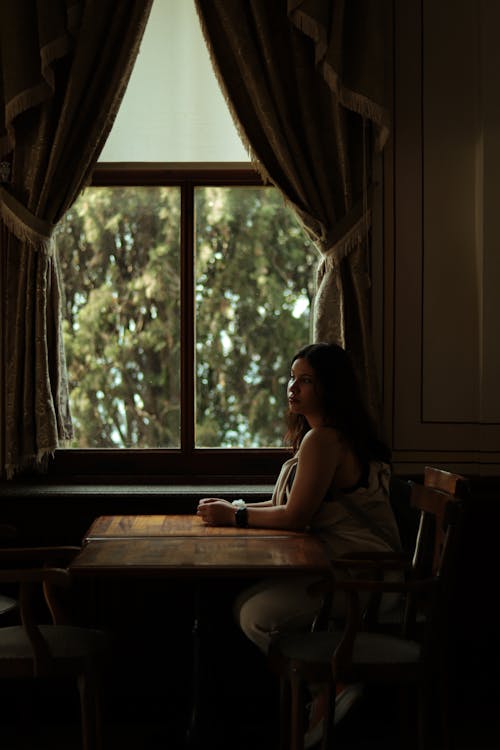Brunette Woman Sitting by the Window 