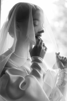 Graceful bride in a satin wedding dress and veil, captured in Ukraine.