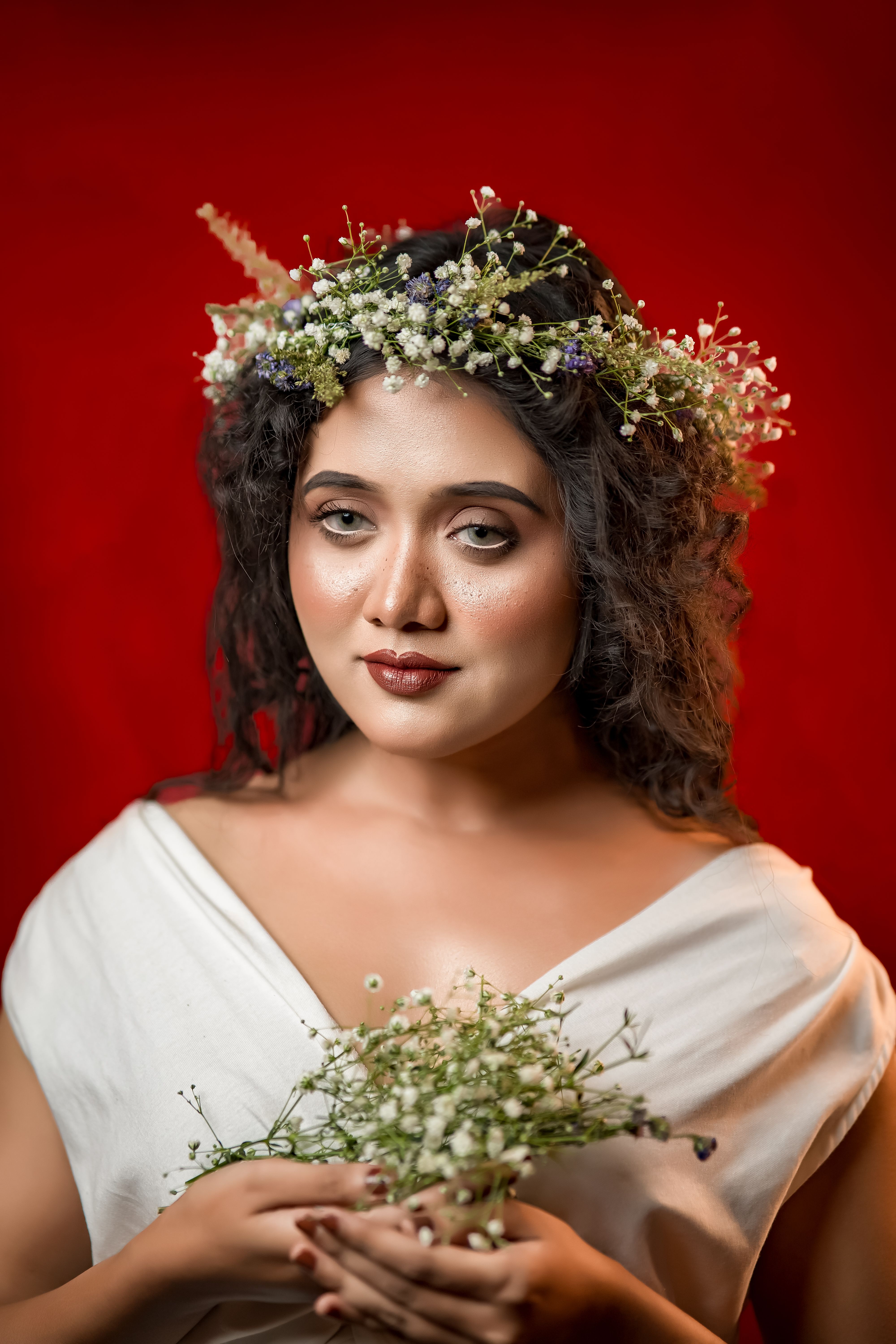 A sophisticated portrait of a woman with a floral crown against a vibrant red backdrop.. sophisticated, portrait, woman