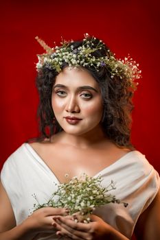 A sophisticated portrait of a woman with a floral crown against a vibrant red backdrop.. sophisticated, portrait, woman