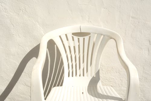 White Plastic Chair Standing at a White Wall