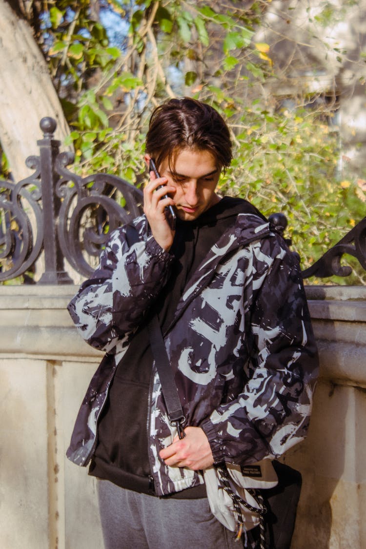 Boy In A Jacket Calling Someone On A Smartphone