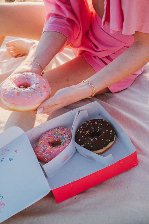 Woman Sitting with a Box of Donuts 