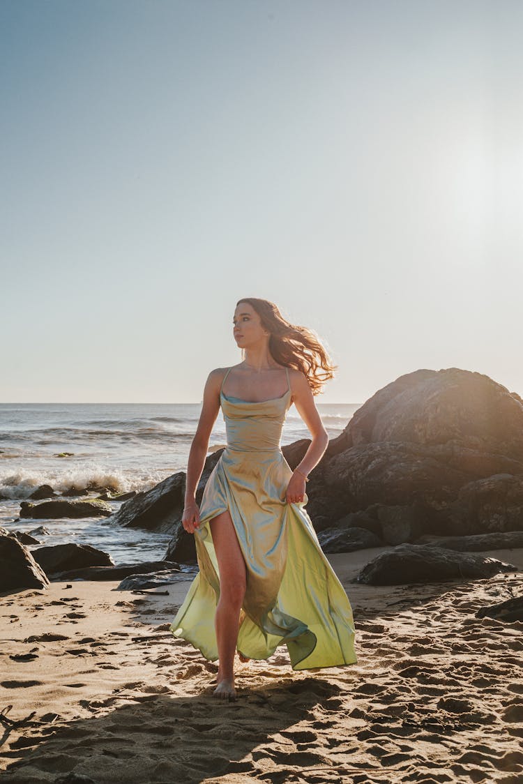 Woman In A Dress Walking On A Beach 