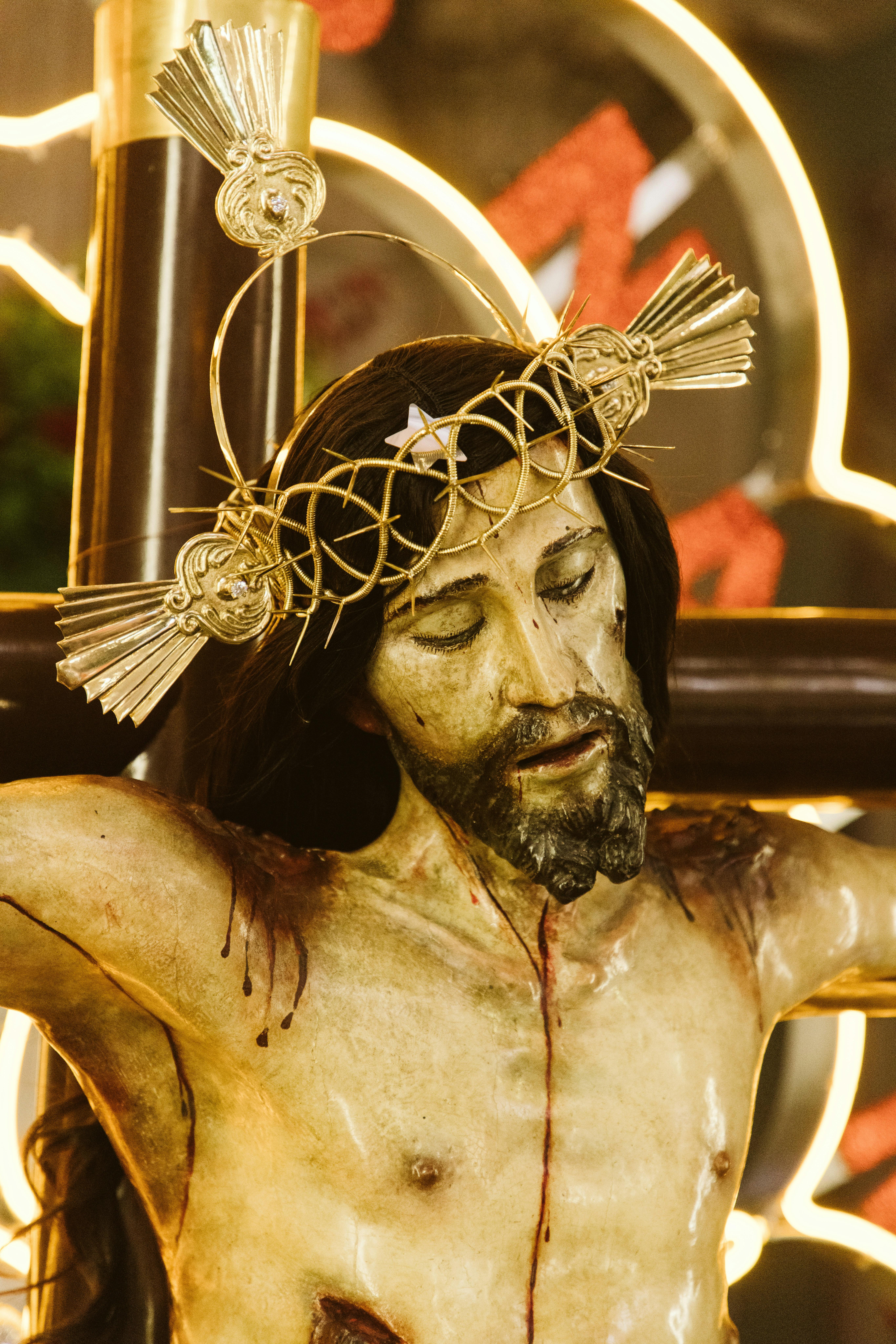 Close-up of a crucifixion sculpture depicting Jesus Christ with a crown of thorns and halo.