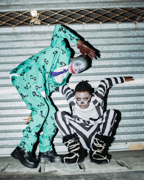 Free Two adults in creative Halloween costumes pose playfully on city streets. Stock Photo