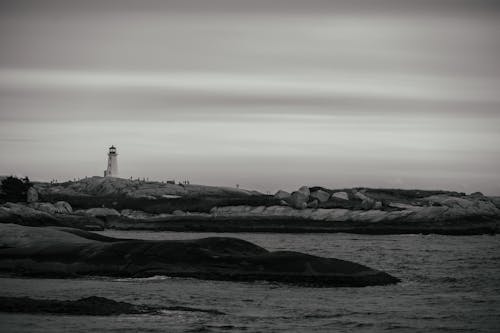 Black and White Photograph of a Rocky Coast with a Lighthouse