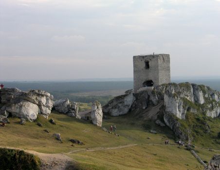 Ancient tower ruins on a rocky hillside with scenic views.