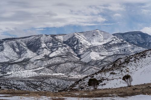 Free A breathtaking view of snow-covered mountains under a cloudy sky. Stock Photo