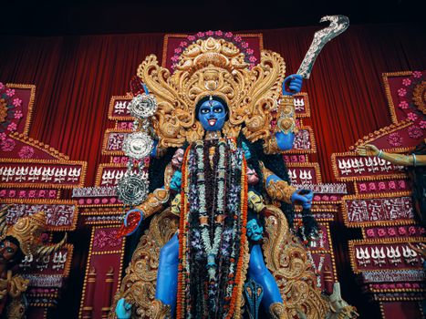 Ornate statue of Goddess Kali during Durga Puja in Kolkata, adorned in gold and intricate decorations.