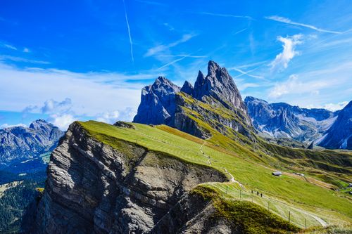 Free Stunning aerial view of the Dolomite peaks and lush meadows under a clear blue sky. Stock Photo