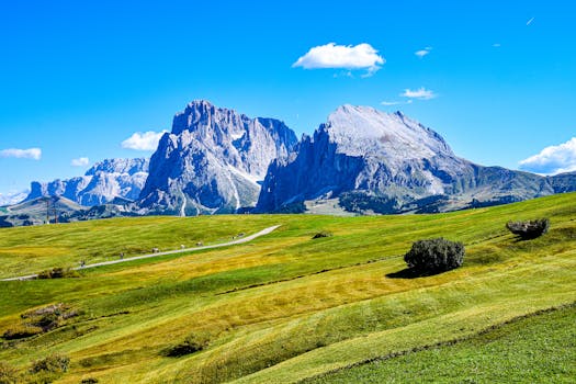 Experience the stunning scenery of the Dolomites with lush green grasslands under a vibrant blue sky.