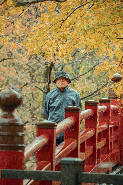 Man on Red Bridge in Rain