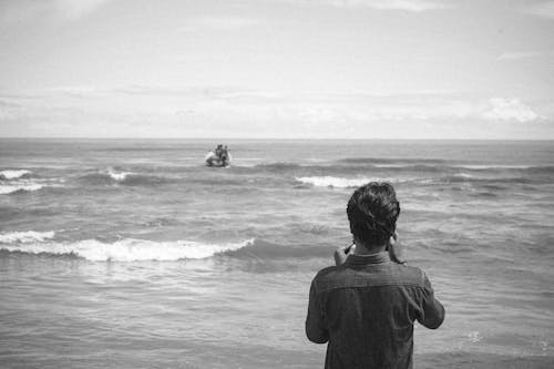 Back View of a Man Standing on the Shore 