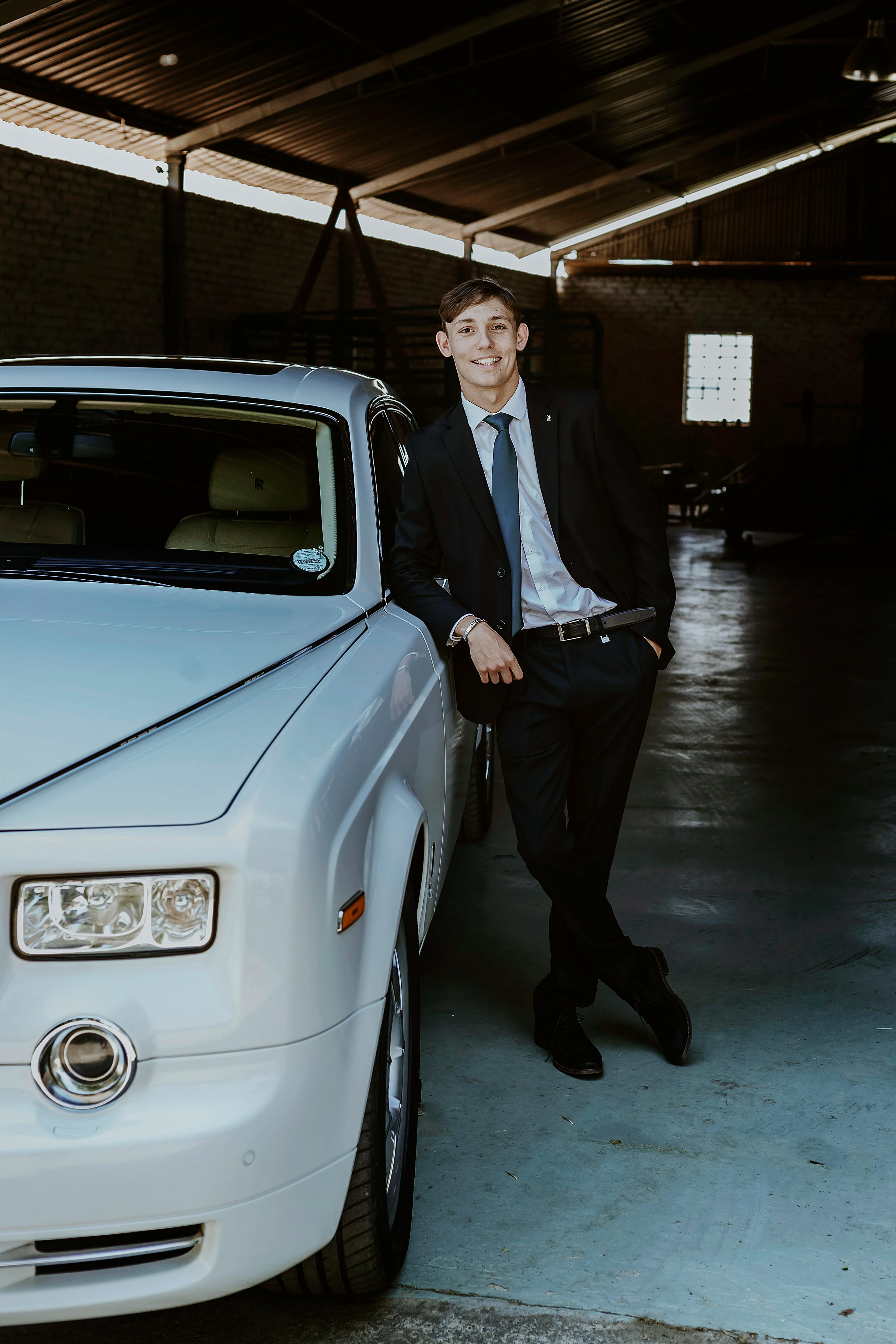 Stylish man in suit leaning on a premium car indoors. Captured in Pretoria.
