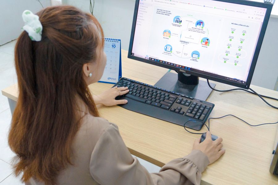 Young woman using desktop computer in office setting in Hanoi, Vietnam.