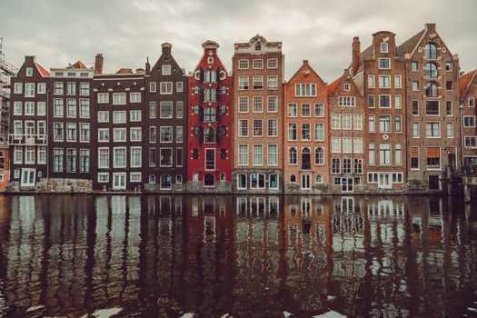 Scenic view of colorful canal houses in Amsterdam with water reflections, capturing urban architecture.