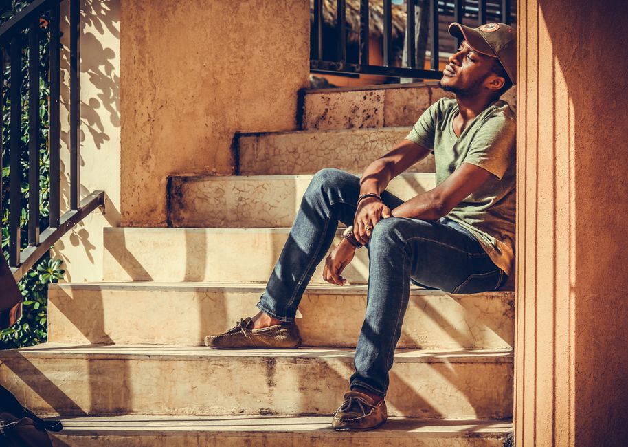 A fashionable man in casual attire enjoys sunlight on an outdoor staircase, exuding a relaxed vibe. A fashionable man in casual attire enjoys sunlight on an outdoor staircase, exuding a relaxed vibe.