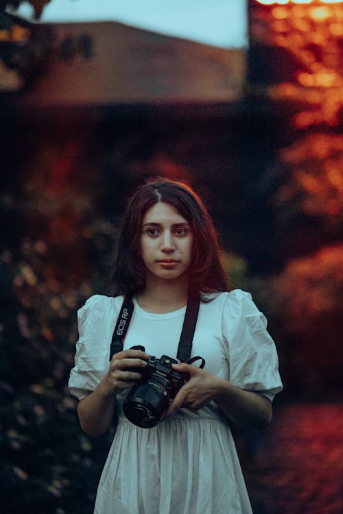 Woman in White Dress Standing with Camera