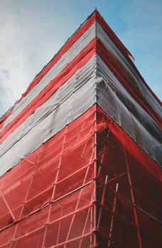 Low-angle view of red scaffolding on a building under construction, Amsterdam.