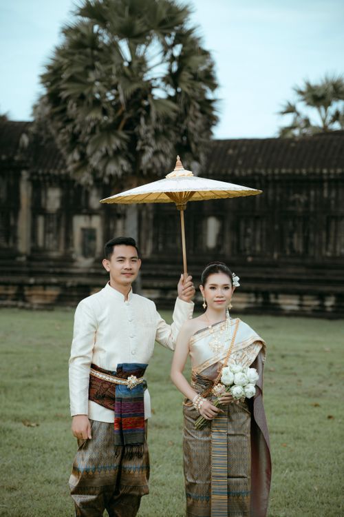 Free Young couple in traditional Cambodian attire posing at Angkor Wat, Siem Reap. Stock Photo