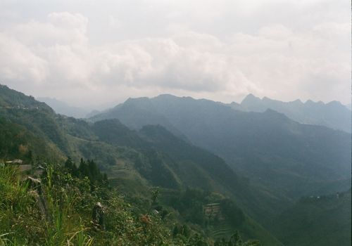 Free Beautiful misty mountain range with lush valleys and soft sunlight, creating a serene landscape. Stock Photo
