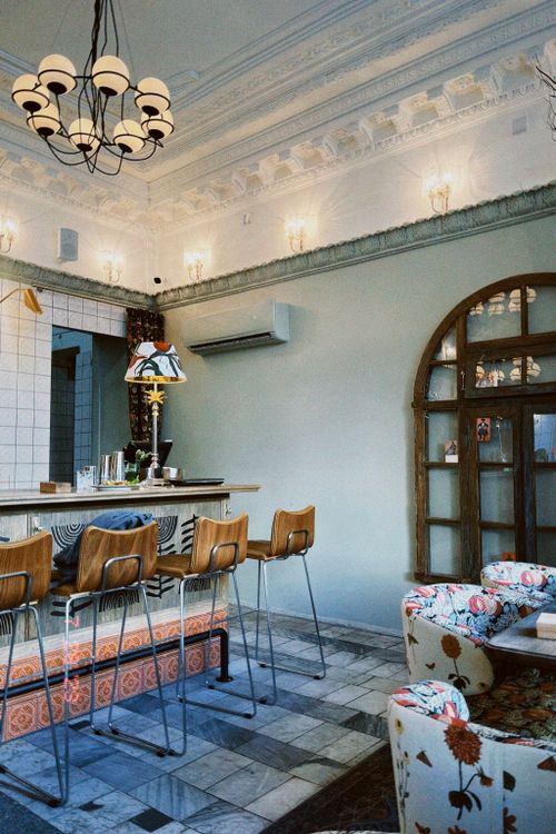 Free Chic restaurant interior featuring a classic chandelier, bar counter, and stylish chairs. Stock Photo