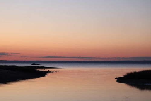 Free Peaceful twilight scene of a seaside landscape with calm waters and pastel skies. Stock Photo