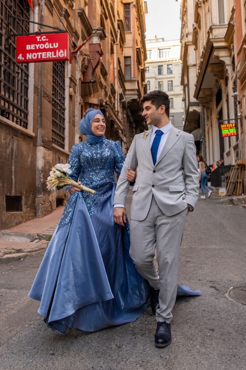 Free A joyful bride and groom walking down an urban street in Beyoğlu, dressed elegantly for a wedding celebration. Stock Photo