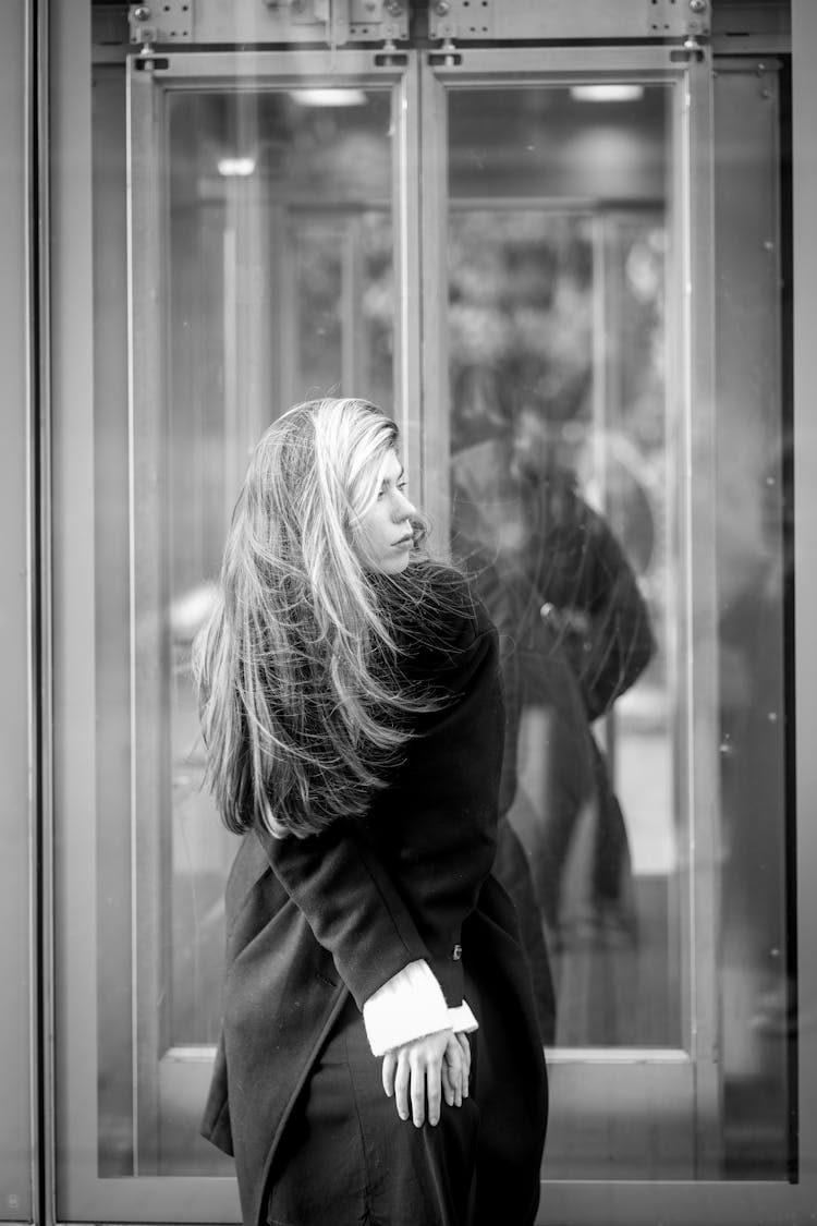 Woman Leaning Forward Waiting On The Sidewalk