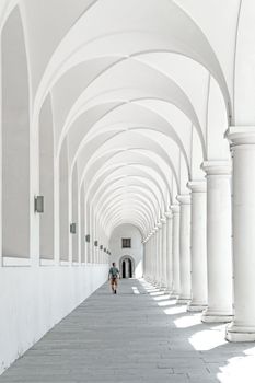 A person walks through the historic arched colonnade in Dresden, Germany, showcasing stunning architecture.