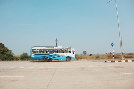 A classic blue bus journeying down a rural road, showcasing travel and adventure.